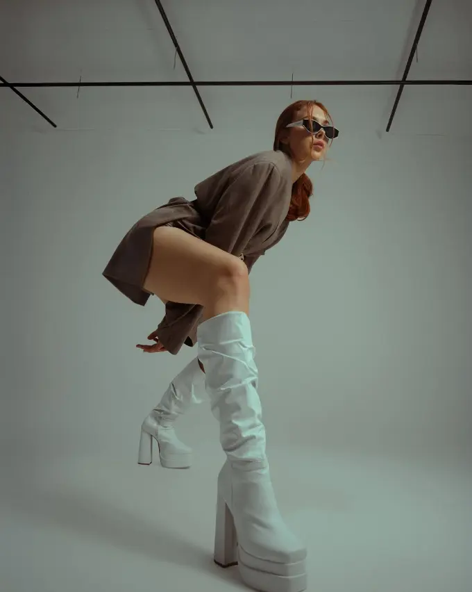 Editorial de moda con botas plataforma blancas en estudio